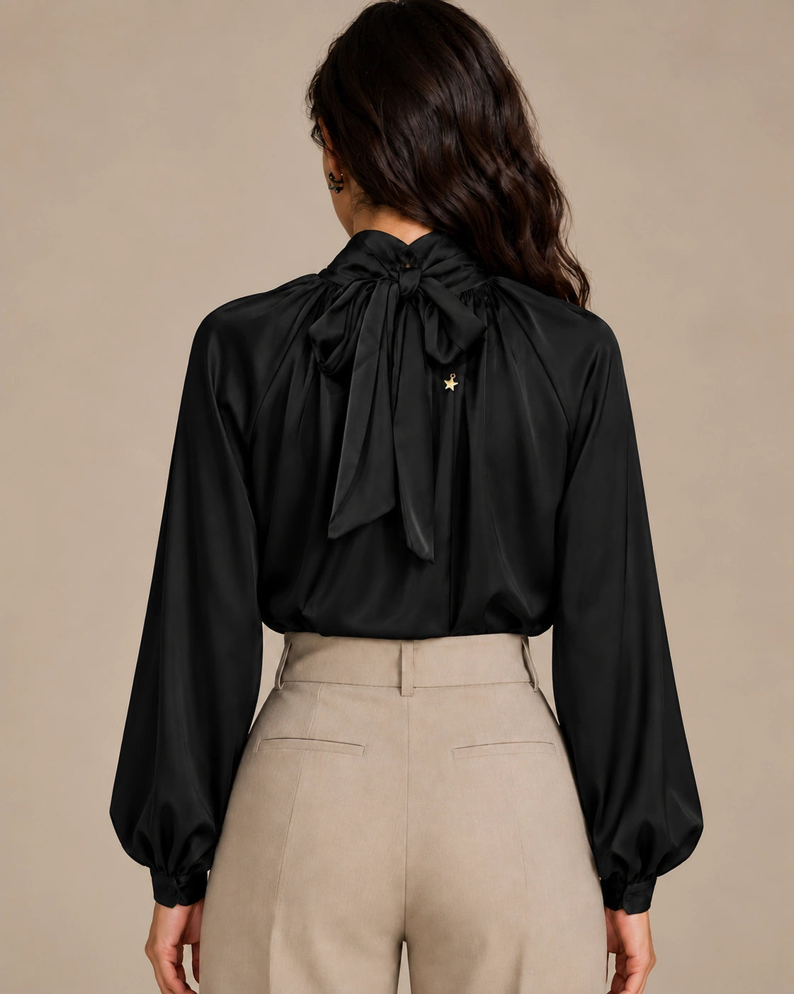 Rear view of the black Zendaya gathered-neck shirt showing its neck tie bow and long gathered sleeves.