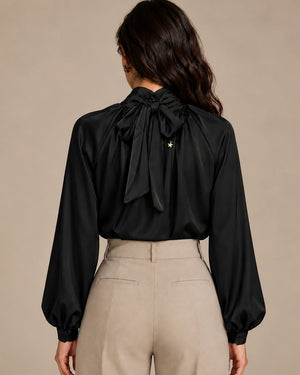 Rear view of the black Zendaya gathered-neck shirt showing its neck tie bow and long gathered sleeves.