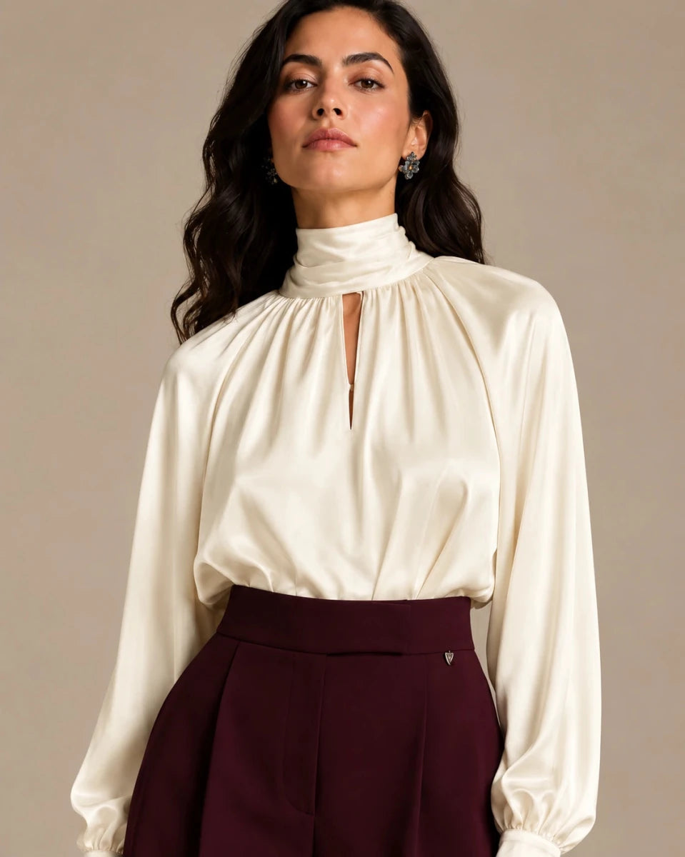 Close-up of the ivory Zendaya Panna shirt showing its gathered high neckline, keyhole opening and long sleeves.