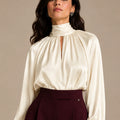 Close-up of the ivory Zendaya Panna shirt showing its gathered high neckline, keyhole opening and long sleeves.